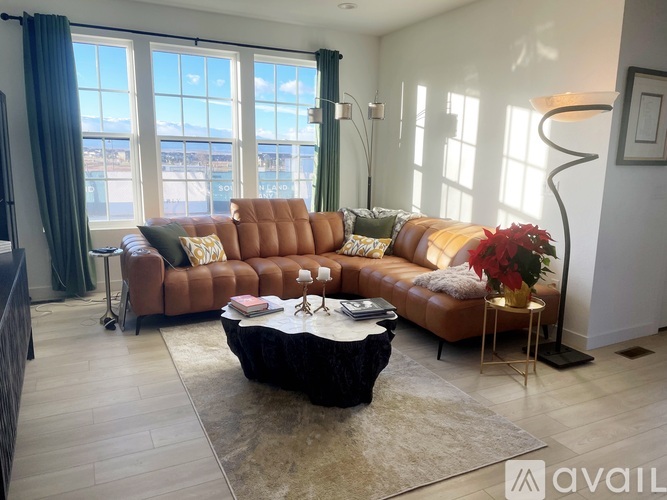 A living room with a brown leather sofa and a black coffee table.