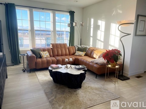 A living room with a brown leather sofa and a black coffee table.