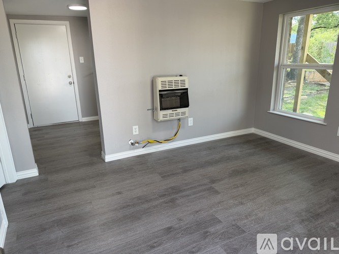 A room with a window, a door, and a wall-mounted air conditioner unit.