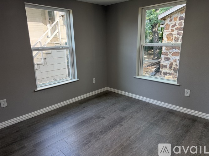 A room with grey walls and a wooden floor is shown.