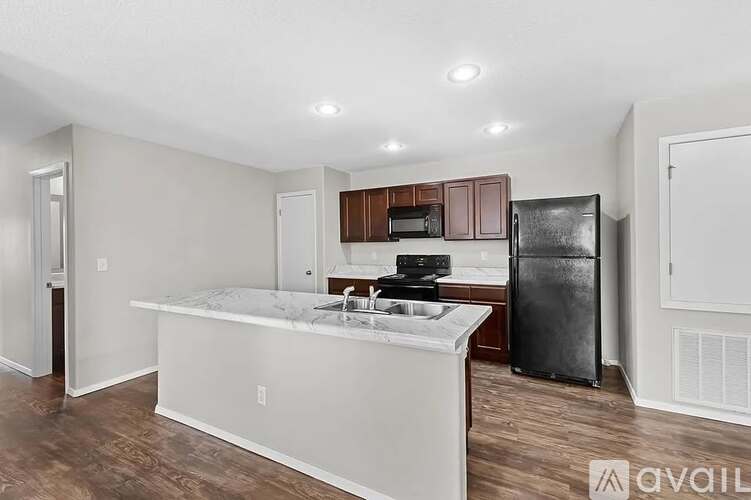 A kitchen with a refrigerator, microwave, and oven.