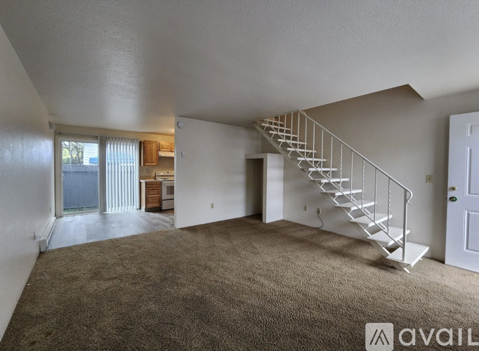 A spacious room with a staircase leading to another level.
