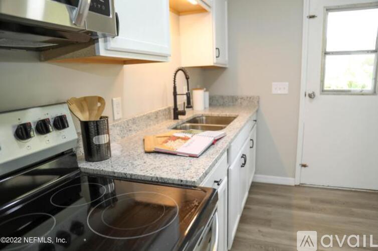 A kitchen with a stove top oven and a sink.