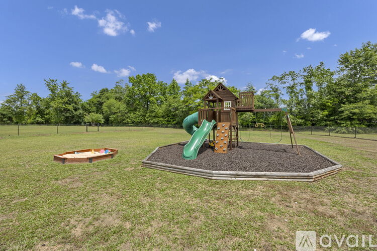 A playground with a green slide and a wooden structure.
