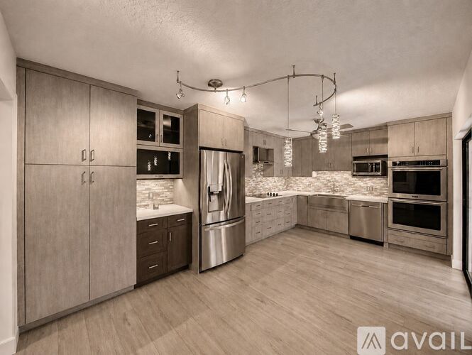 A spacious kitchen with wooden cabinets and stainless steel appliances.