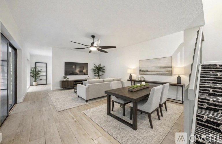 A modern living room with a dining table and chairs.