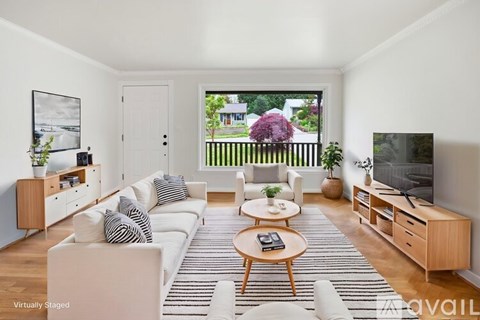 A living room with a white couch and a wooden coffee table.