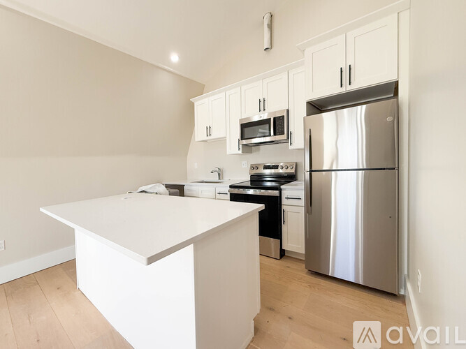 A kitchen with a white countertop and stainless steel appliances.