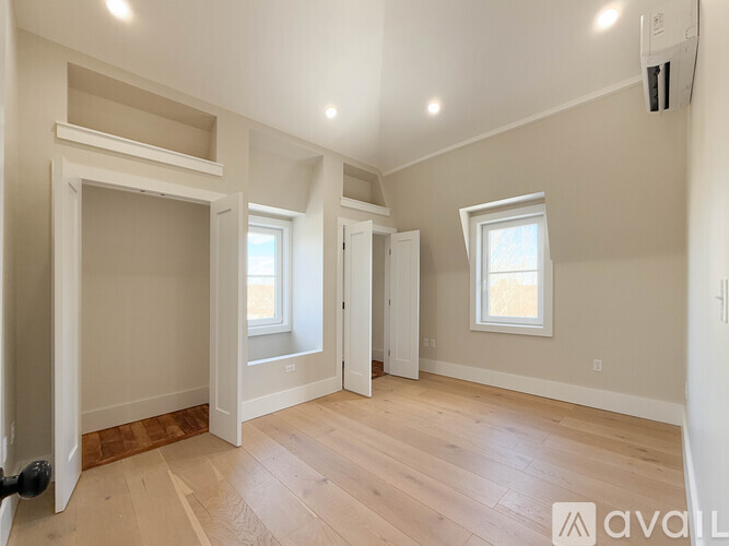 A spacious room with wooden floors and white walls.