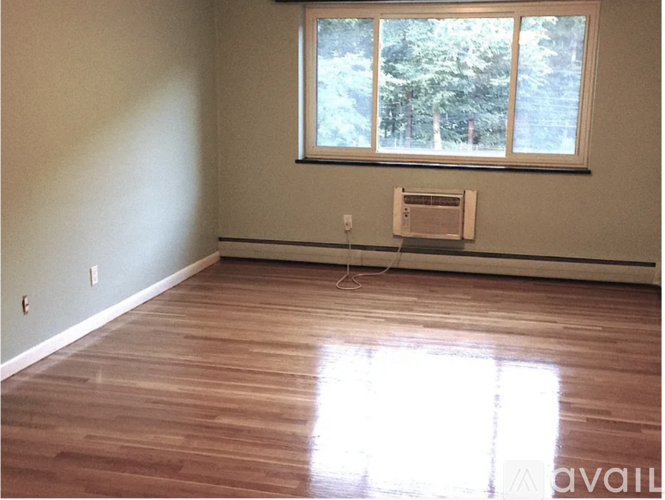 A room with a window and a wood floor.