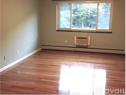 A room with a window and a wood floor.