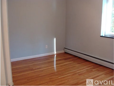 A room with wooden flooring and a window.