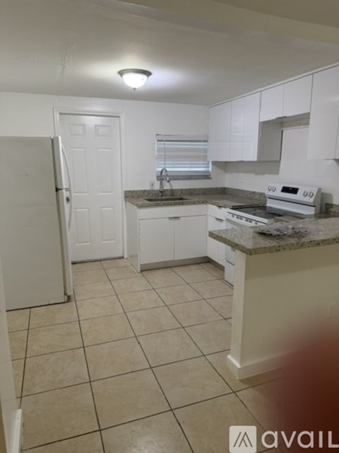 A kitchen with white cabinets and a granite countertop.