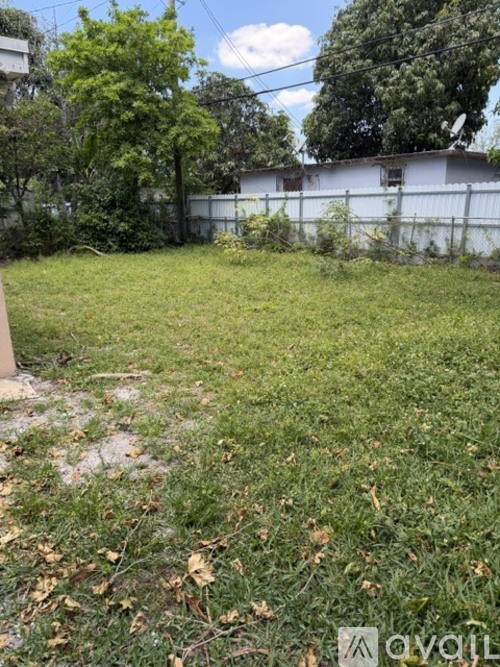 A backyard with a fence and some trees.