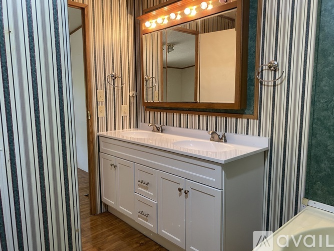 A bathroom with a vanity and striped wallpaper.