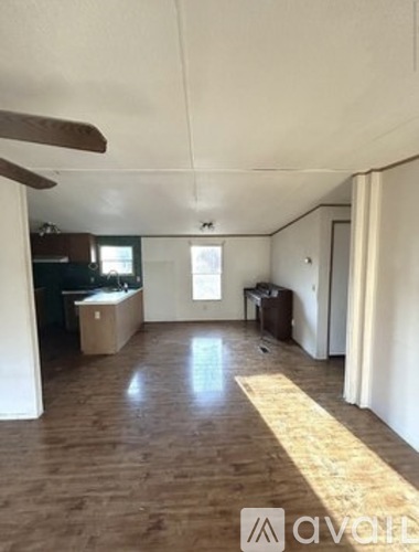 A room with wooden flooring and a window.