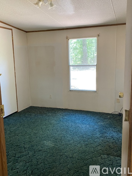 A room with a window and Avail apartments logo.