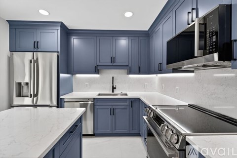 A kitchen with dark blue cabinets and stainless steel appliances.