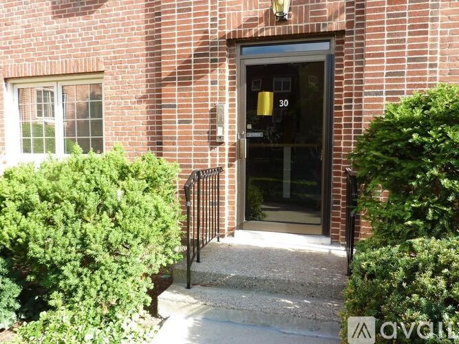 A brick building with a black door and a number 30 on it.