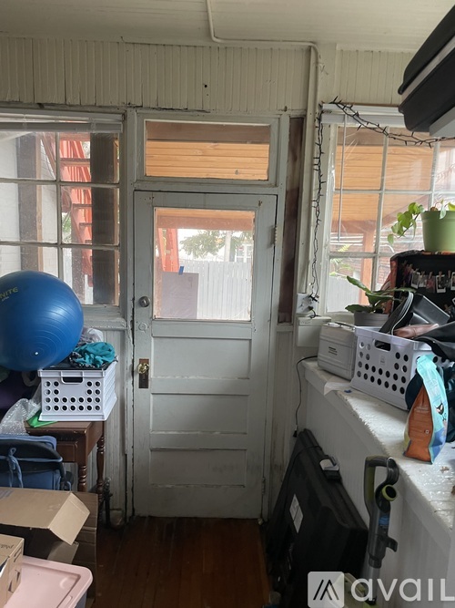 A room with a white door and a window with a view of a building outside.