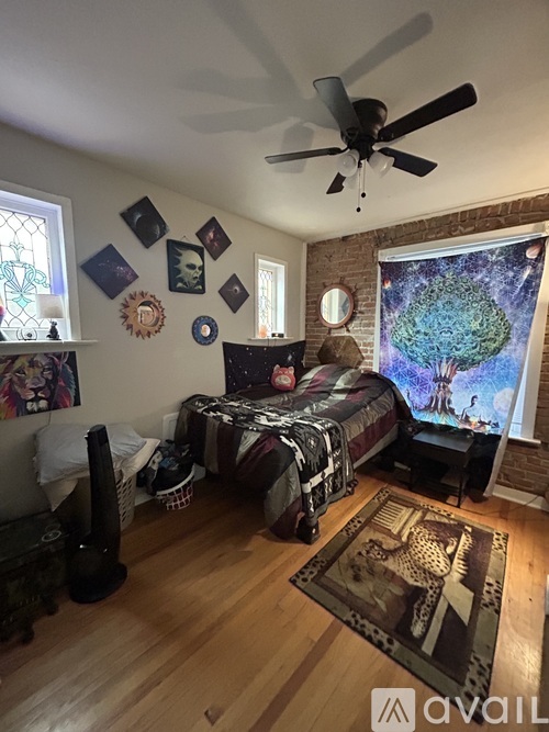 A bedroom with a bed, a ceiling fan, and a rug on the floor.