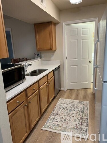 A kitchen with wooden cabinets and a white fridge.