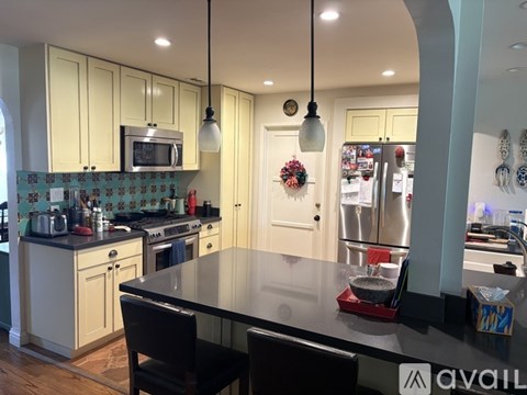 A kitchen with a black table and chairs.