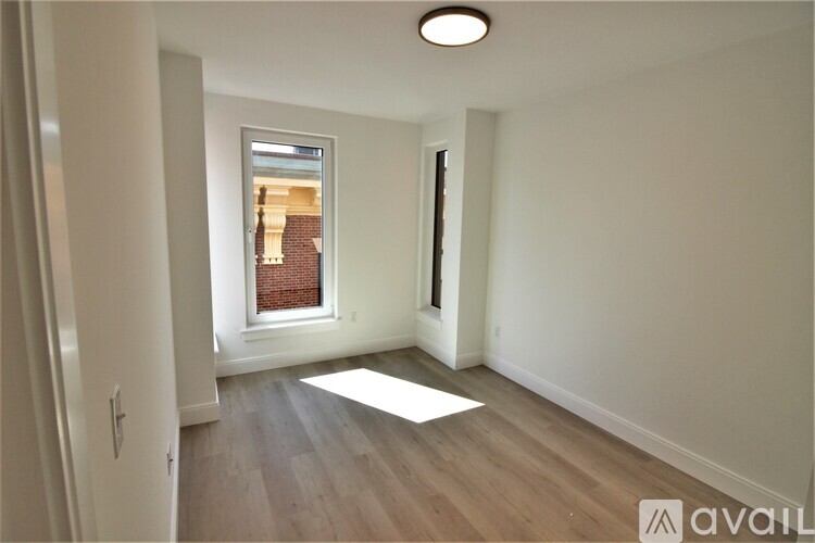 A room with a window and wooden flooring is available for rent.