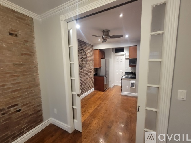 A room with a brick wall and wooden flooring.