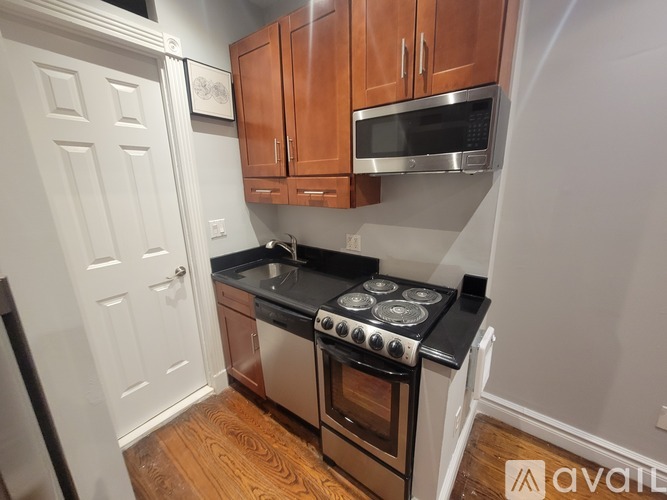 A kitchen with wooden cabinets and a black stove top.
