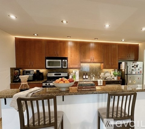 A kitchen with wooden cabinets and a granite countertop.
