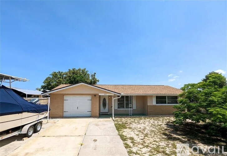 A house with a garage and a boat in the driveway.