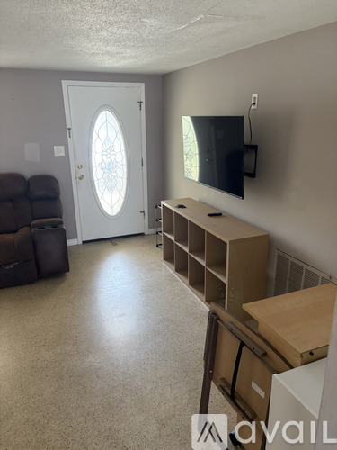 A small house with a white garage door is for sale.