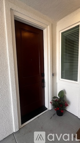 A brown door is on the left and a window with blinds is on the right.