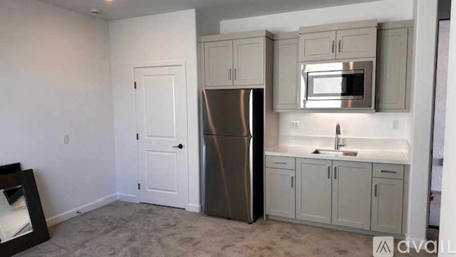 A kitchen with a fridge, microwave, and cabinets.