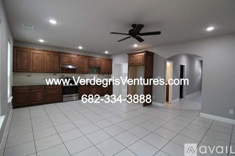 A kitchen with wooden cabinets and a ceiling fan.