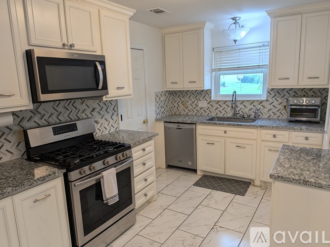 A kitchen with a black stove top oven and white cabinets.