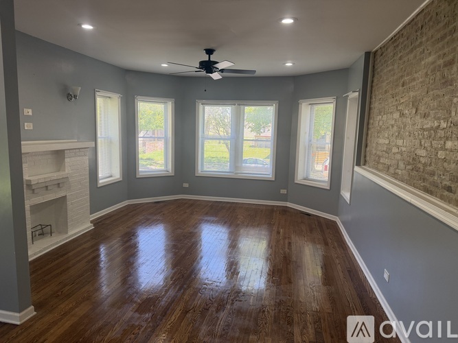 A room with a fireplace and wood flooring.