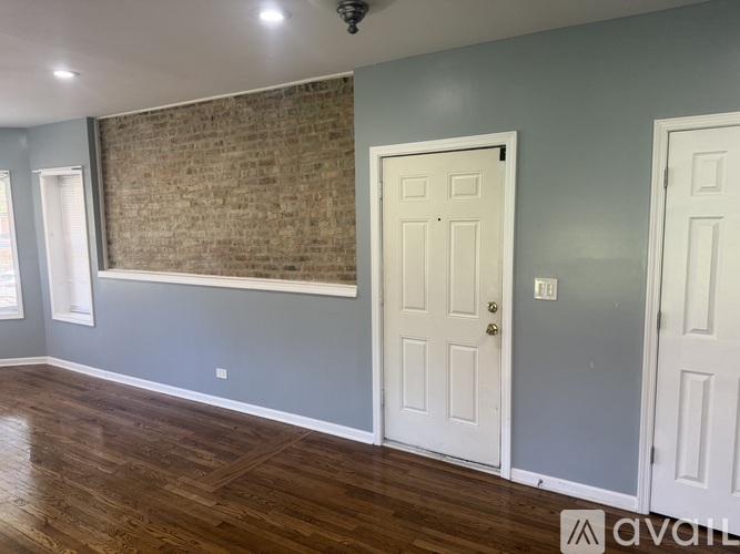A room with a wooden floor and a brick wall.