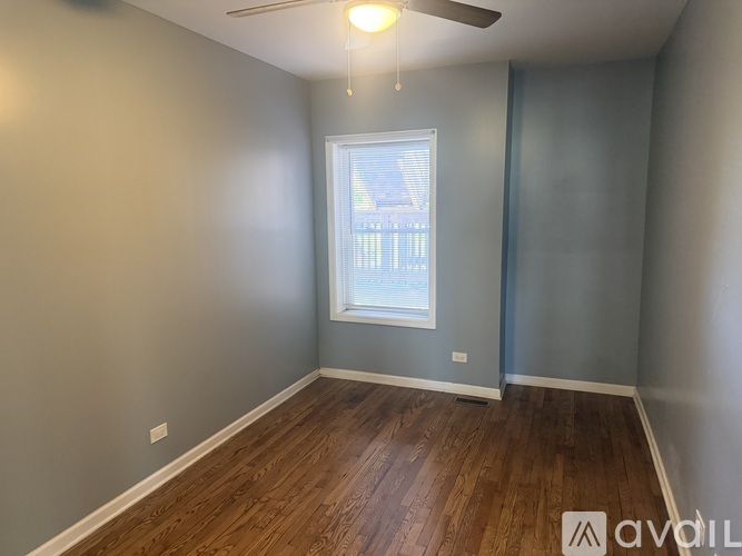 A room with a window and wooden flooring.