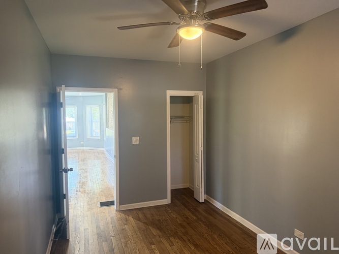 A room with a ceiling fan and two doors.