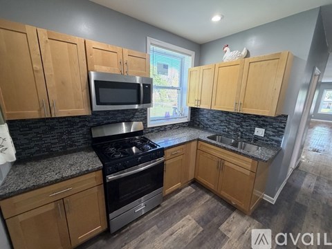 A kitchen with wooden cabinets and a black countertop.