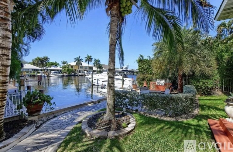 A palm tree stands in a well-manicured yard.