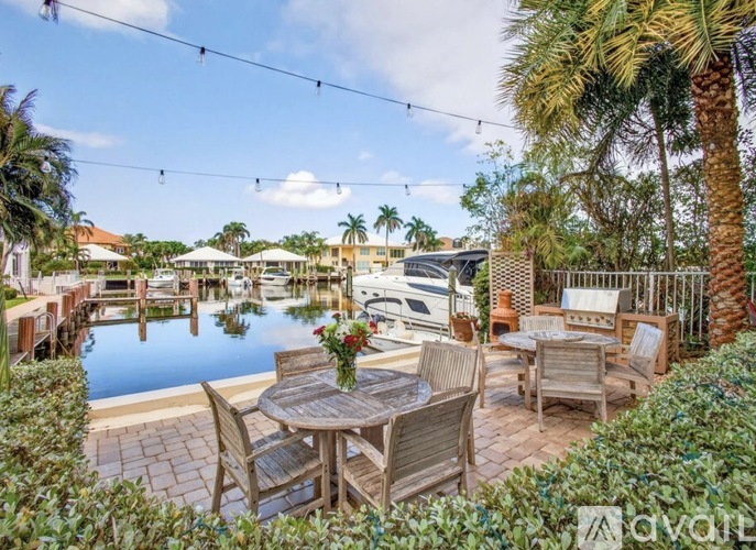 A patio with a table and chairs overlooking a body of water.