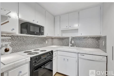 A kitchen with white appliances and cabinets.