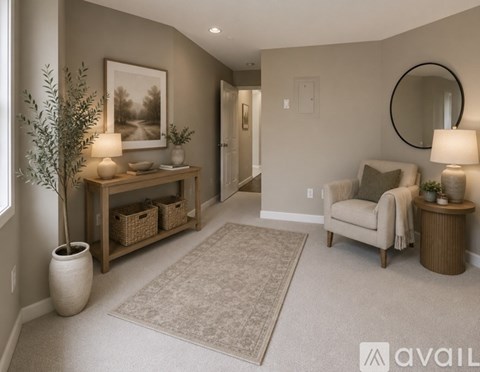 A well-lit living room with a couch, a table with a lamp, and a potted plant.