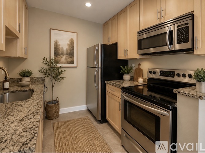 A kitchen with a refrigerator, oven, and microwave.