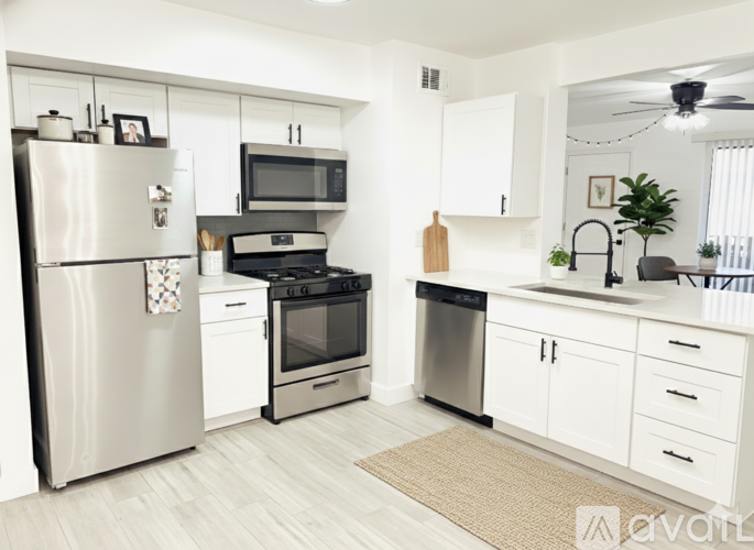 A modern kitchen with white cabinets and stainless steel appliances.