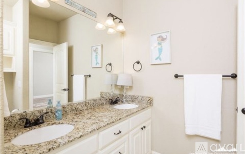 A bathroom with a marble countertop and a white towel hanging on the door.