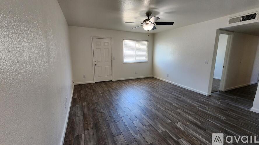 A room with wooden flooring and a ceiling fan.